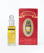 Ruh Kewda attar perfume oil bottle with ornate glass stopper beside red decorative box